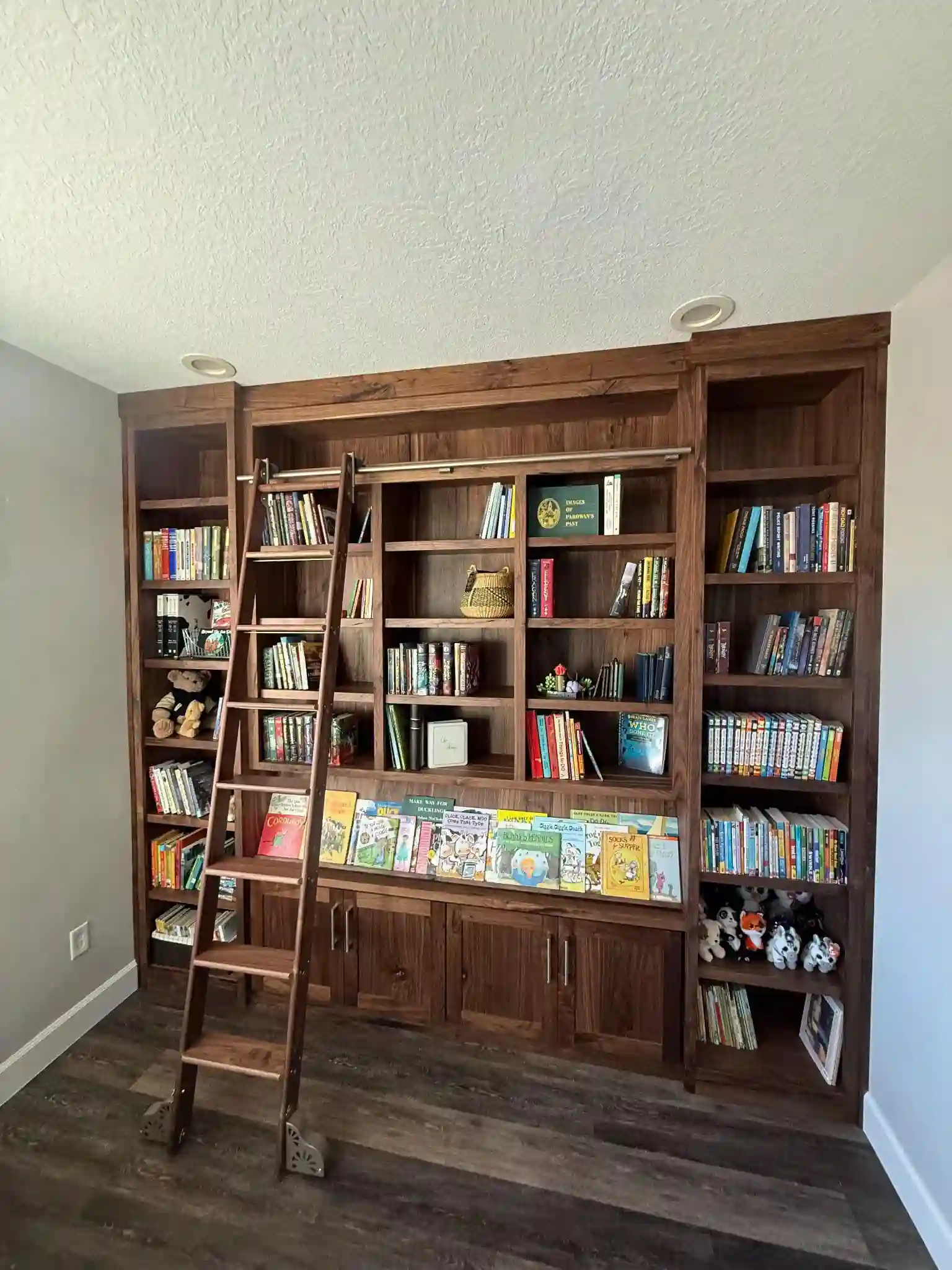 Floor-to-ceiling custom library cabinetry with rolling ladder